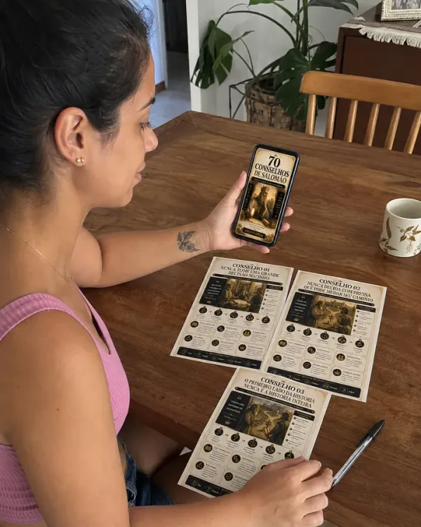 Consultando o material no celular, com três mapas impressos na mesa de jantar